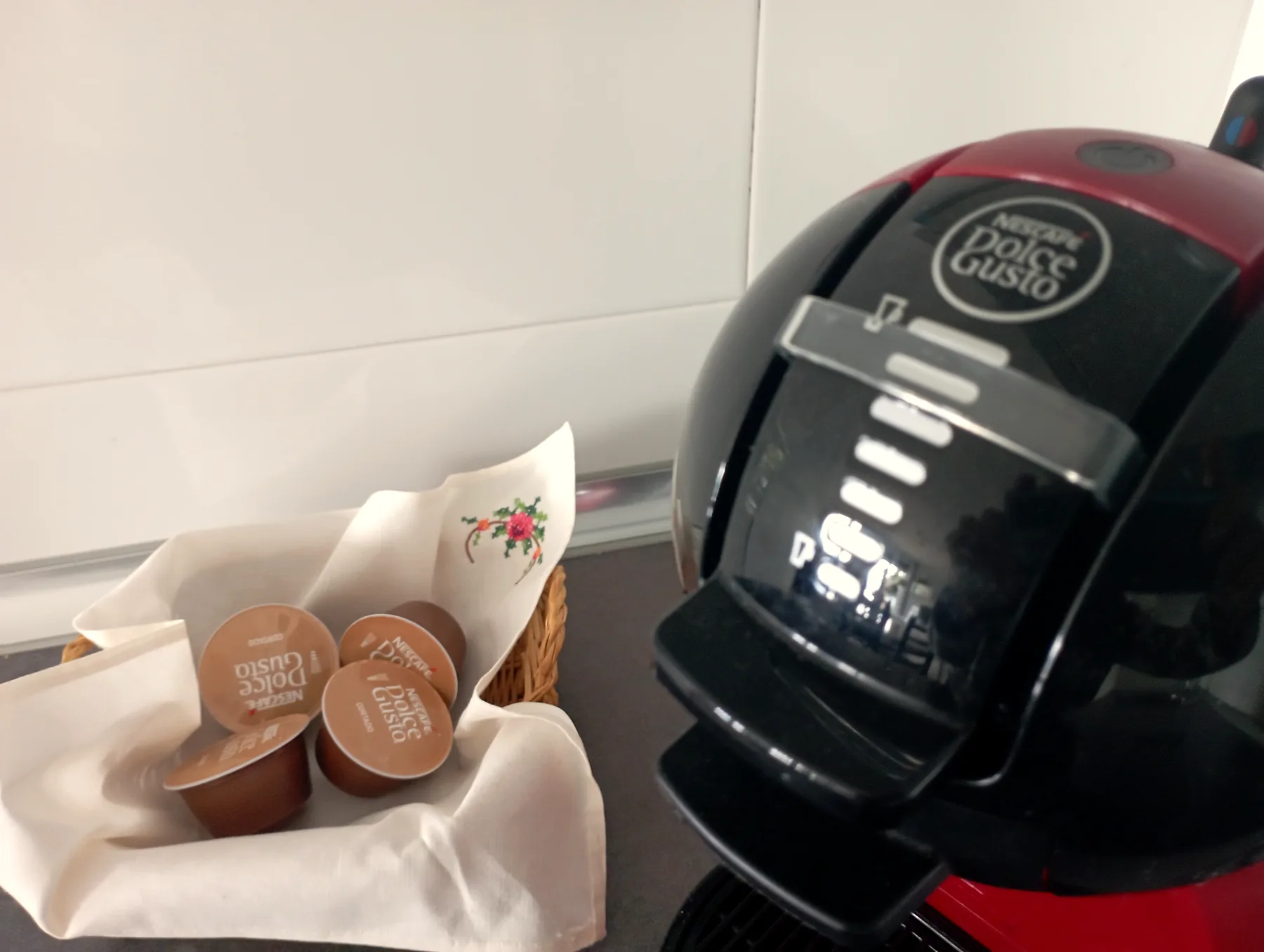 Cafetera Dolce Gusto con cápsulas de cortesía en la cocina