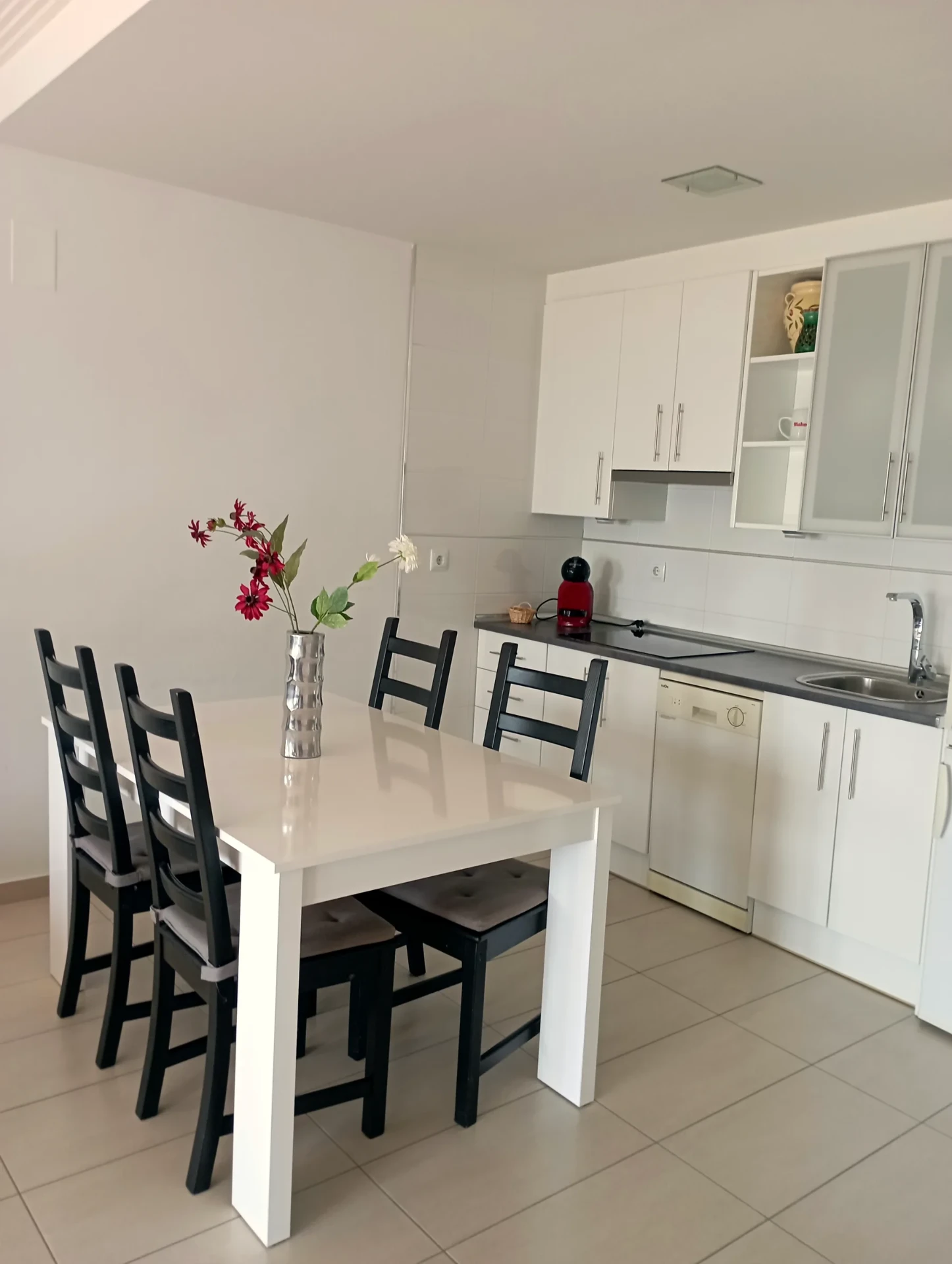 Cocina equipada integrada con mesa de comedor para cuatro personas