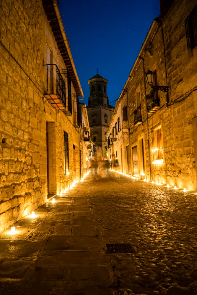 Calle empedrada del casco histórico de Baeza iluminada con velas