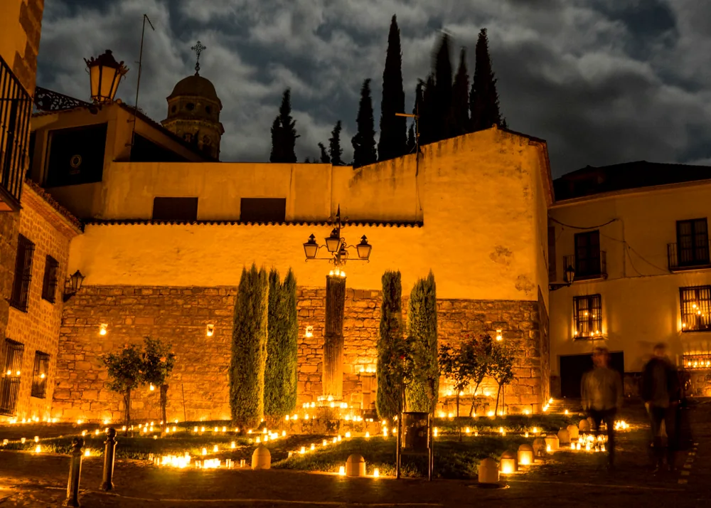 Cipreses y muralla de Baeza de noche durante la Noche de las Velas