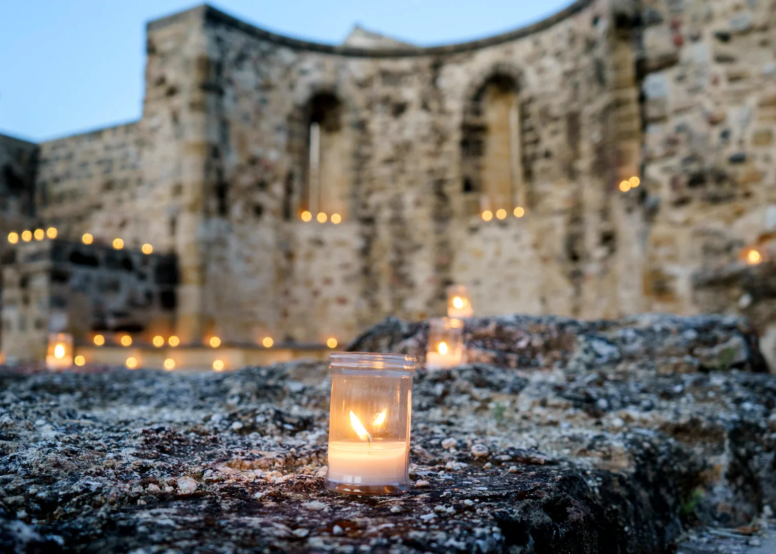 Vela encendida junto a las ruinas históricas de Baeza al atardecer