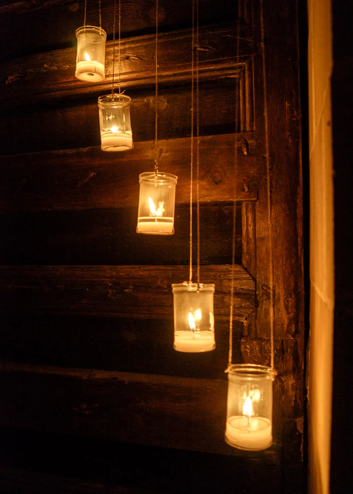 Velas colgantes de cristal en un detalle de madera antigua en Baeza